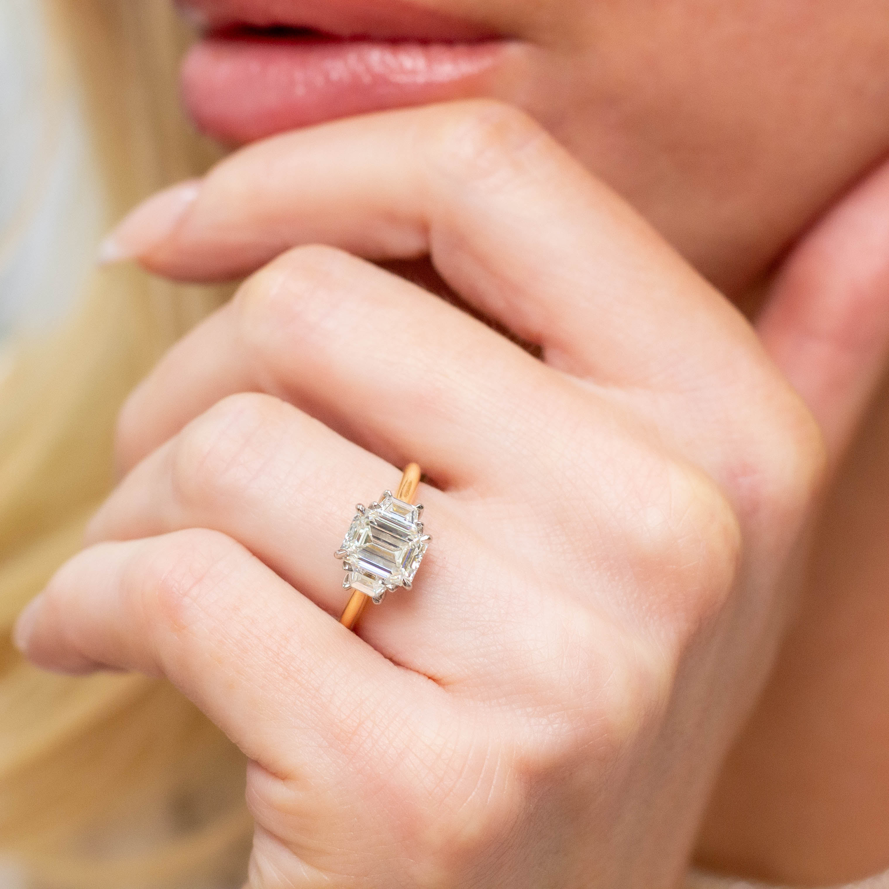 close up of Lauren 18k Two Tone Emerald Cut Diamond Three Stone Ring