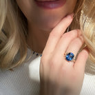 18k Yellow Gold Cushion Cut Sapphire & Trapezoid Diamond Three Stone Ring on a hand