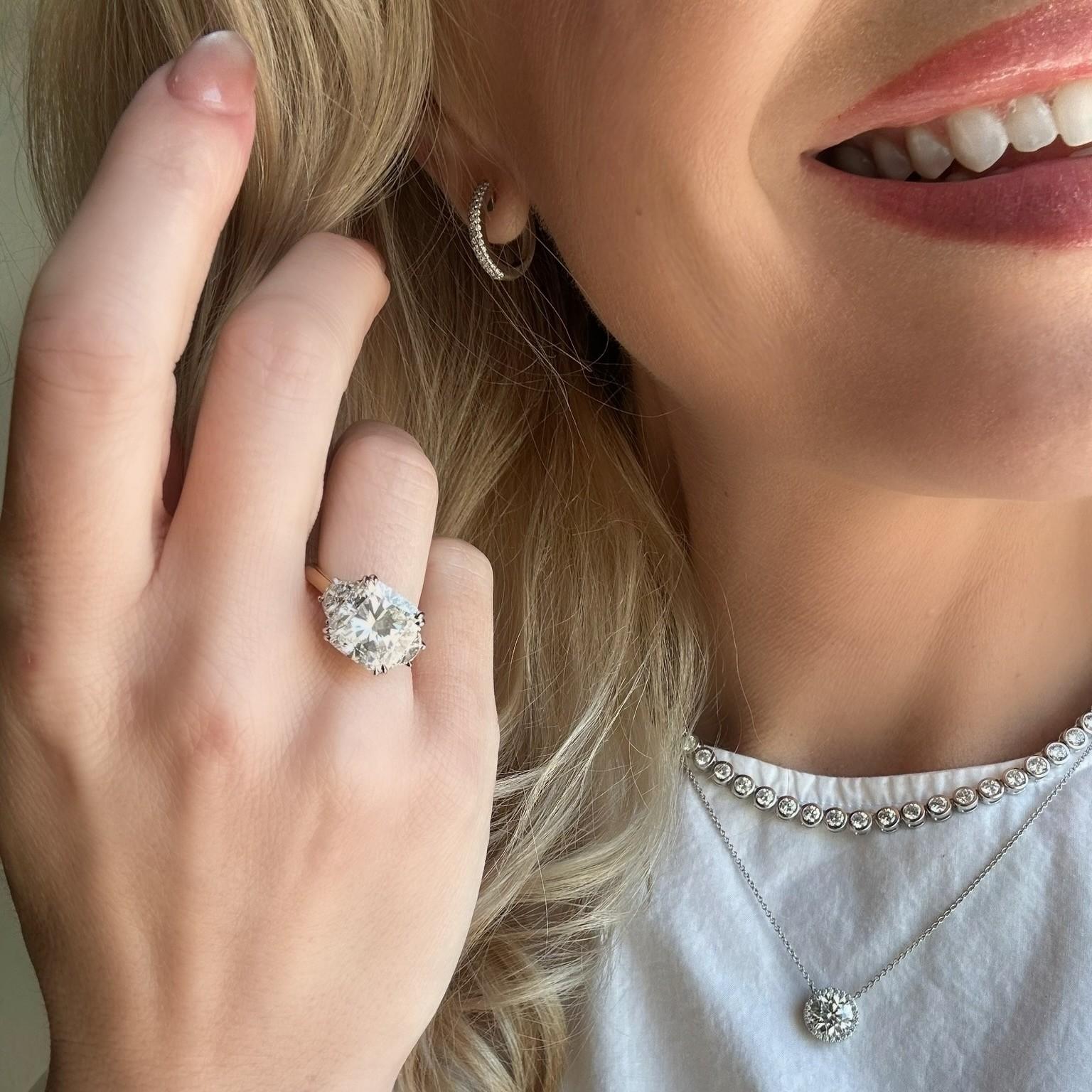 lifestyle image of woman wearing our Taylor 18K Yellow Gold Cushion Cut Diamond Three Stone Ring